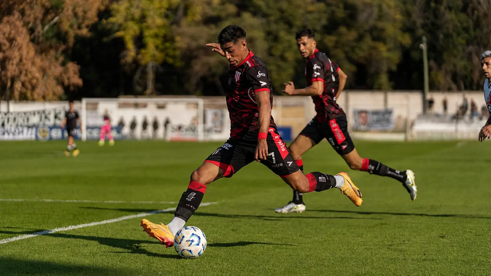 A football player in action wearing a bespoke sublimated football kit